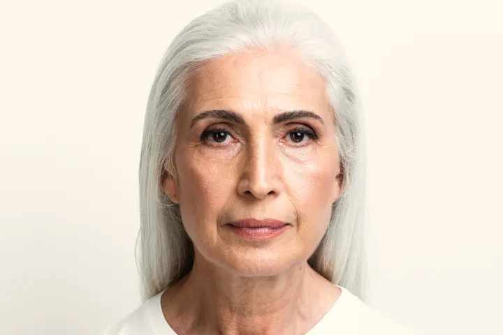 Mulher de cabelos grisalhos com expressão serena.