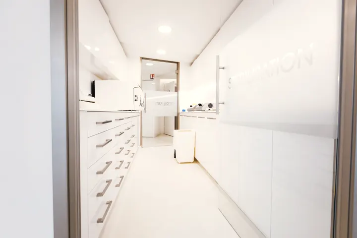 Consultório médico claro e organizado, em tons de branco.